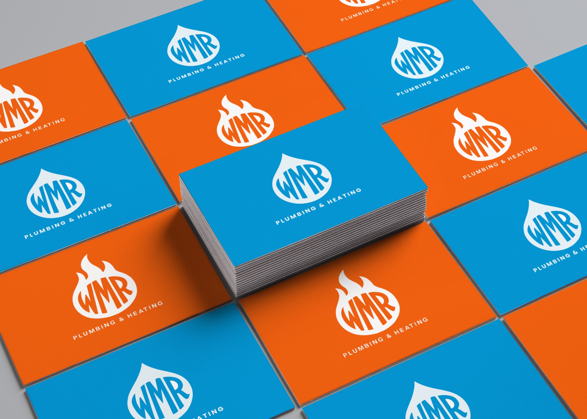 Blue and orange WMR Plumbing and Heating identity shown across an arrangement of business card mockups